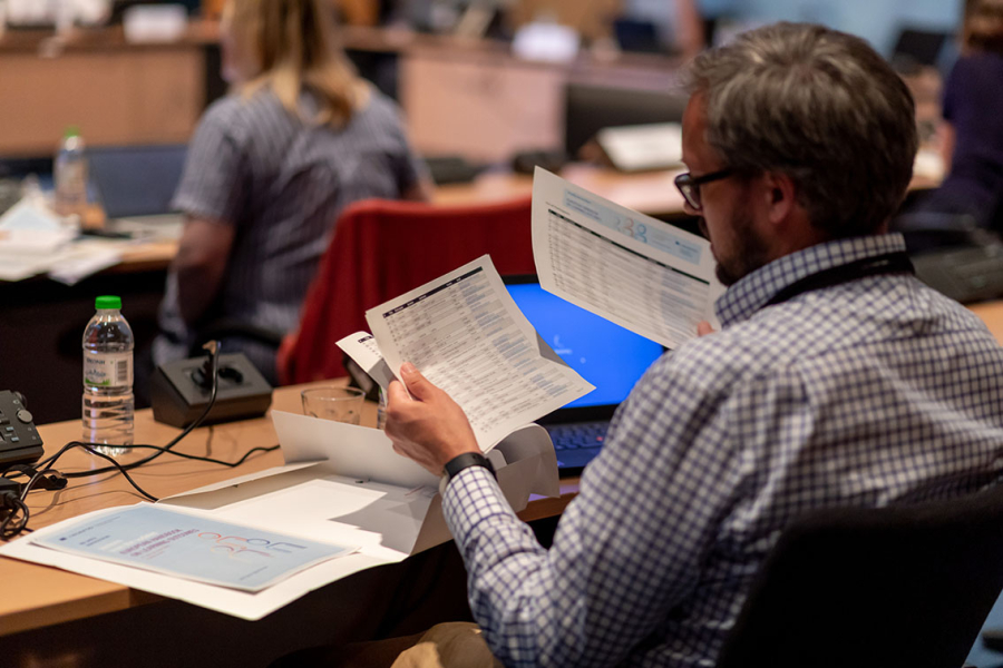 Participant checking the agenda at the 4th policy learning forum on learning outcomes